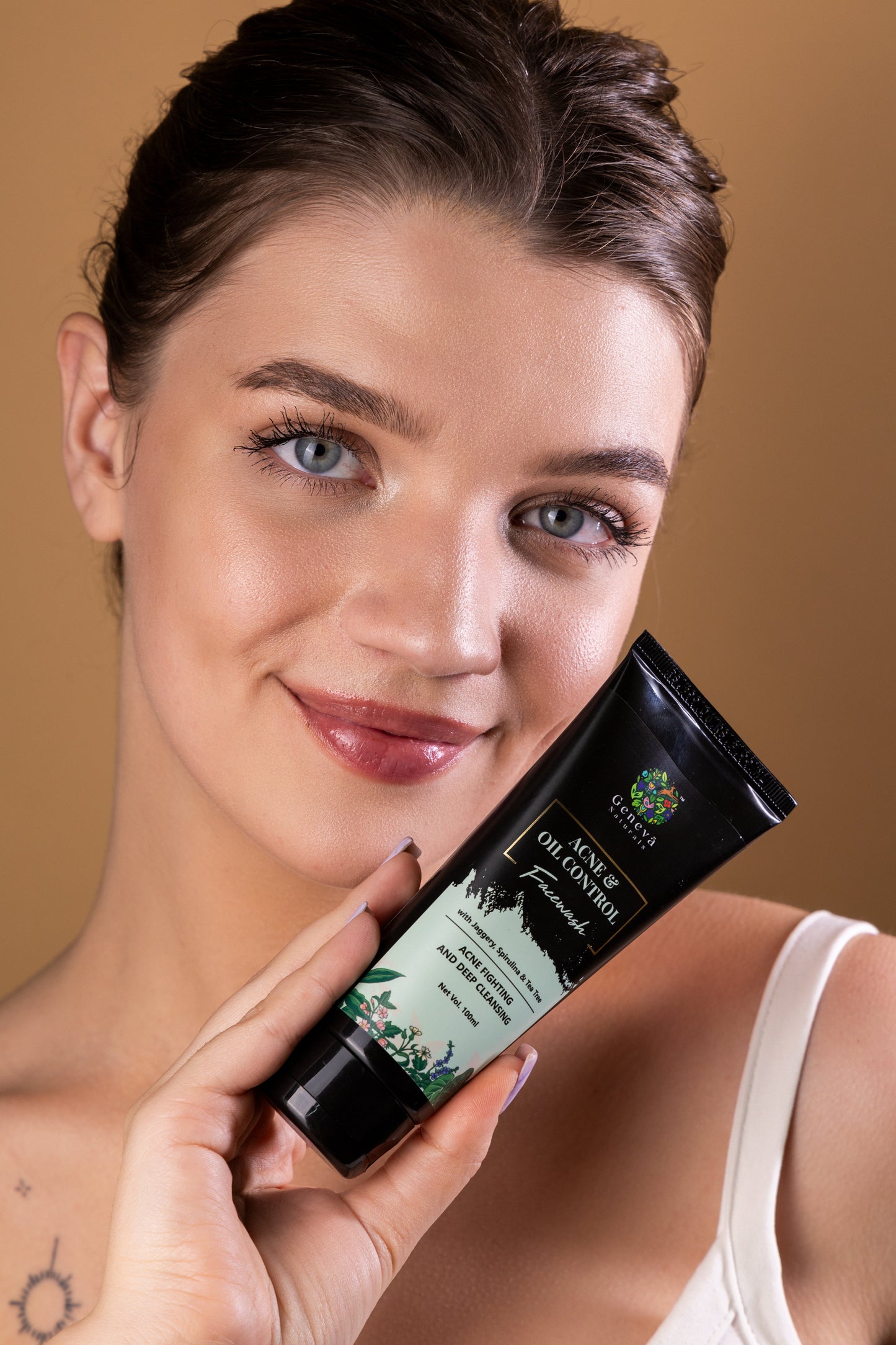 Model with clear glowing skin holding Geneva Naturals Acne and Oil Control Face Wash with Jaggery, Spirulina and Tea Tree – 100ml for acne-fighting skincare
